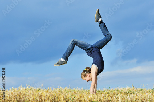 Tablou canvas beautiful girl doing a handstand in a meadow