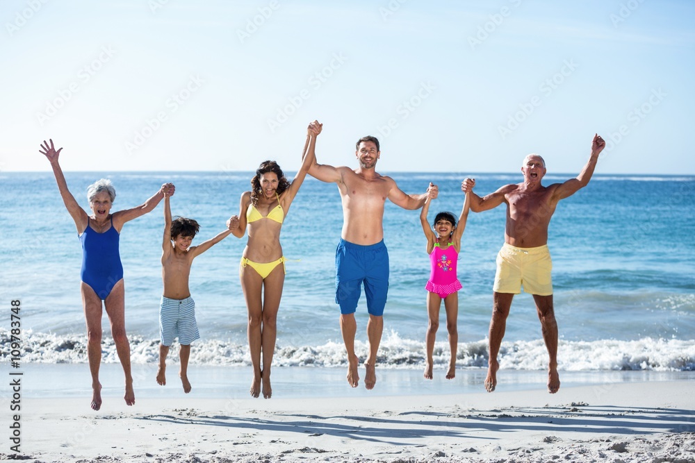 Happy family jumping on the beach