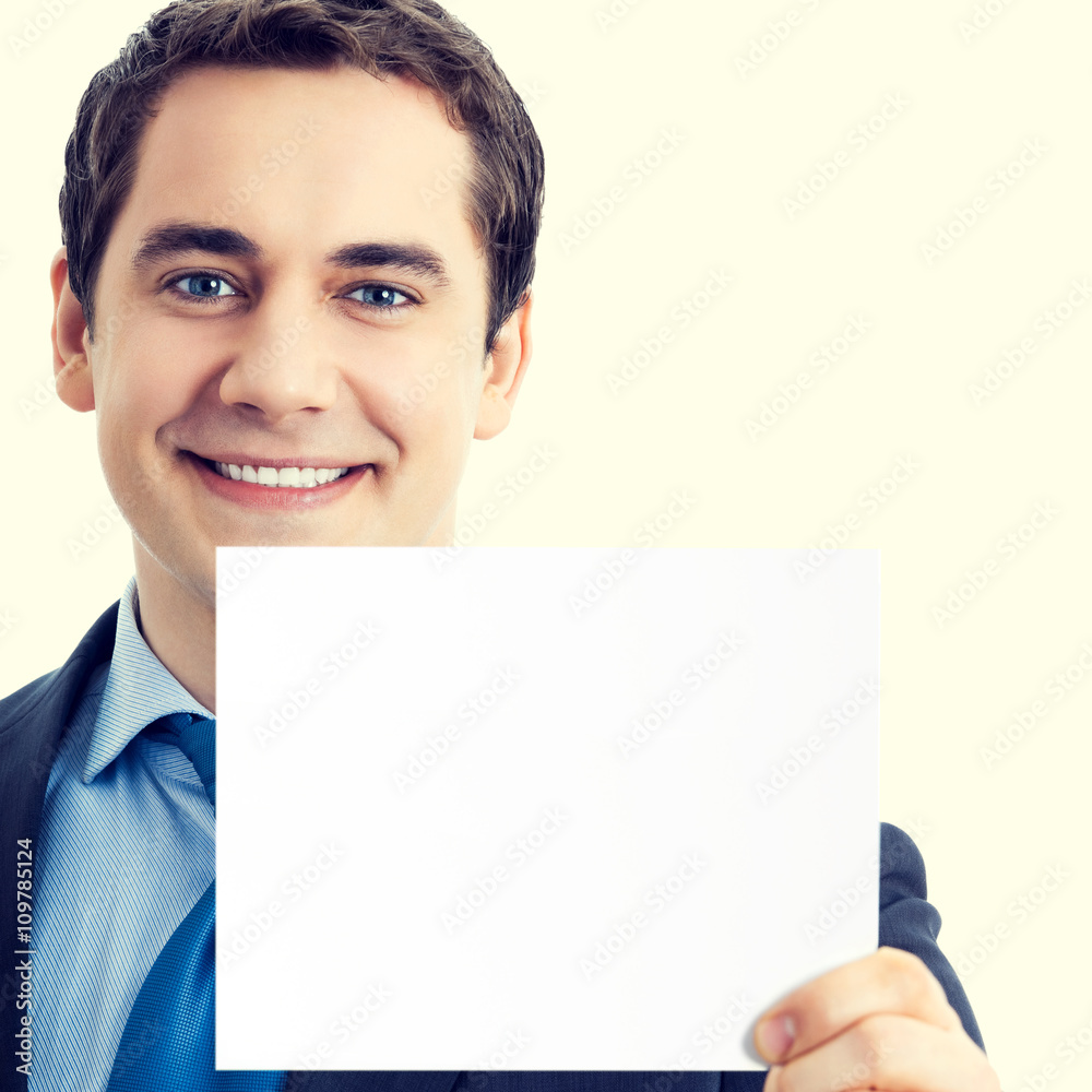 Happy smiling businessman showing blank signboard Happy smiling businessman showing blank signboard