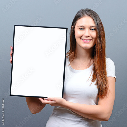Woman holding empty frame with space for your advertisement agai