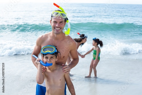 Family wearing diving goggles standing at beach 