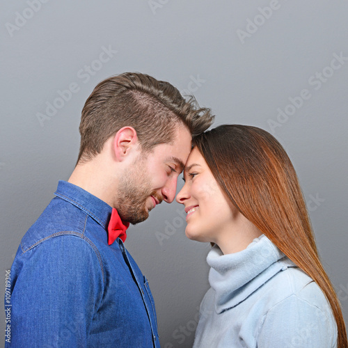 Happy couple in love looking deeply into each others eyes agains