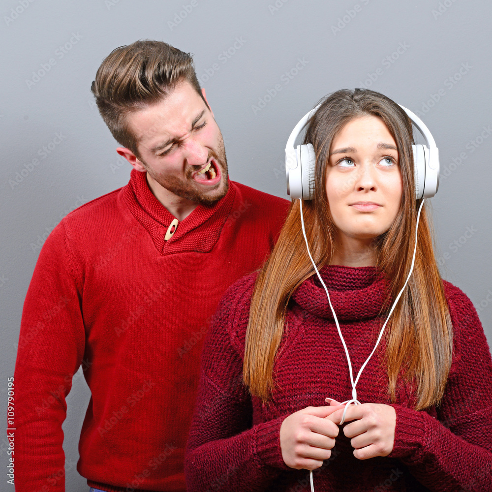 Fényképezés Woman listening to music and doesnt care about him screaming at