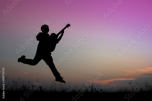 musician playing guitar against the background of sunset © ittipol