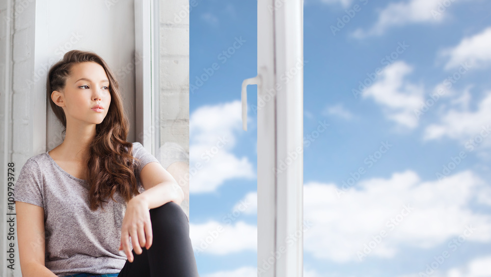 sad pretty teenage girl sitting on windowsill sad pretty teenage girl sitting on windowsill