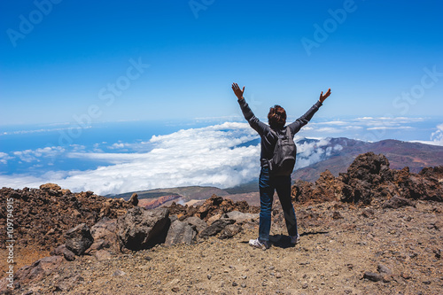 фотографія Mature woman hiker cheering elated with arms raised in the blue sky after hiking