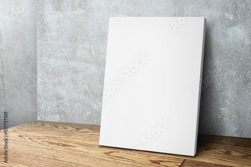 Fotografia, Obraz Blank white canvas frame leaning at concrete wall and wood floor