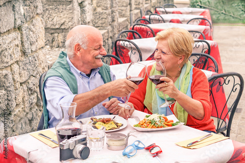 Senior couple drinking and eating in bar restaurant outdoor 