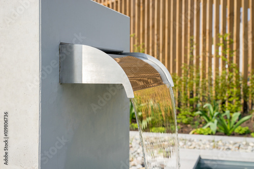 Moderner Wasserfall aus Edelstahl im Garten photo