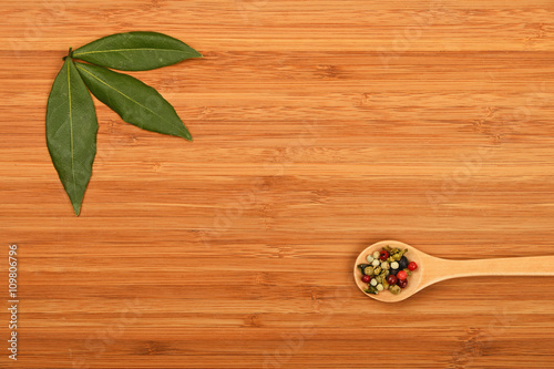 Bay leaves and peppercorn on wood