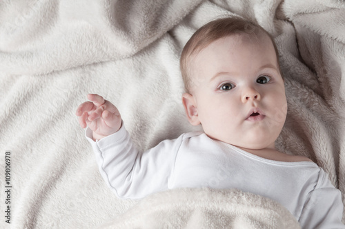 Beautiful little girl lying on her back and posing