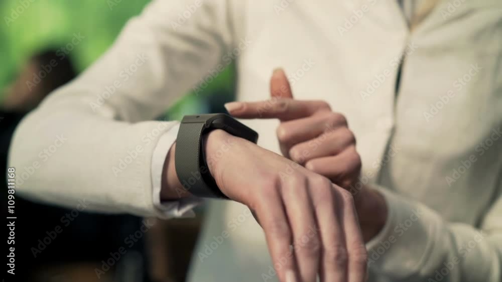 Woman hand using smartwatch sitting in cafe 
