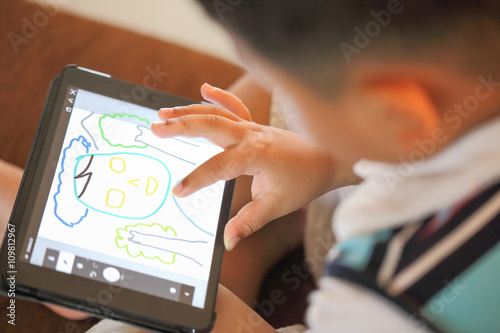Hand of Asian boy playing Tablet fun