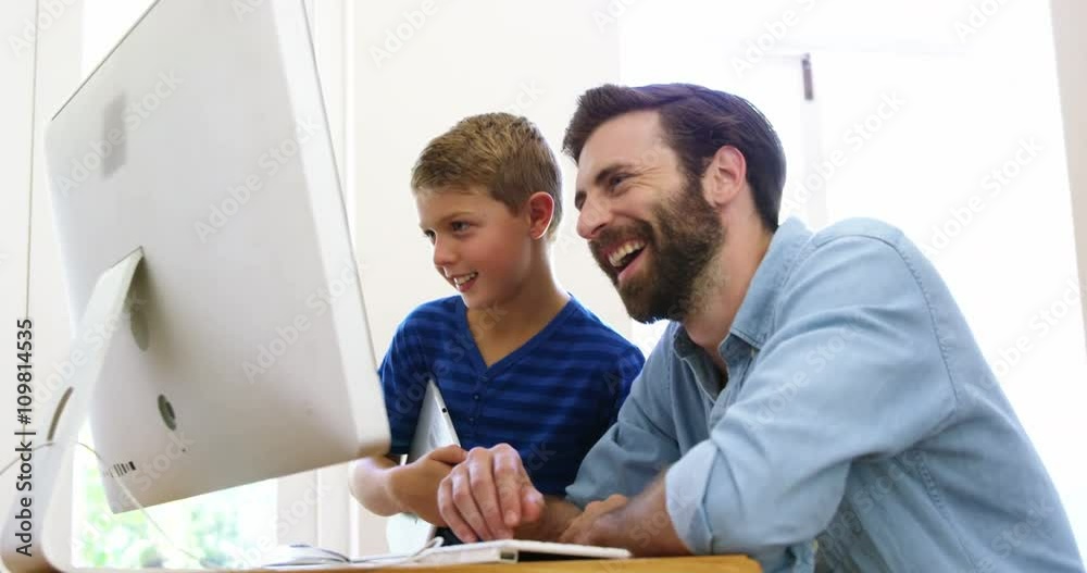 Happy father and son using computer together Happy father and son using computer together
