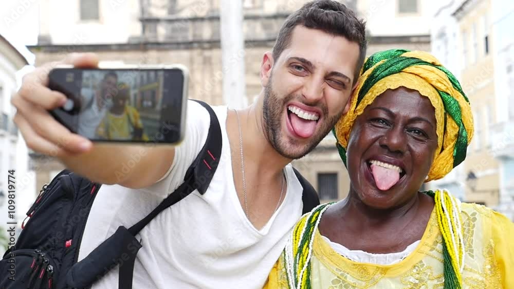 Tourist taking a selfie with a Baiana in the old colonial district of Salvador, Brazil Tourist taking a selfie with a Baiana in the old colonial district of Salvador, Brazil