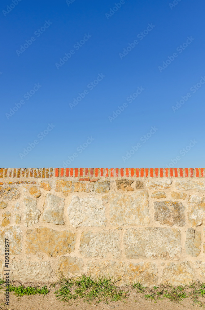 Stone fence against of blue sky