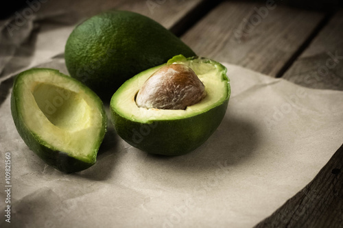 green avocado on the dark wooden table