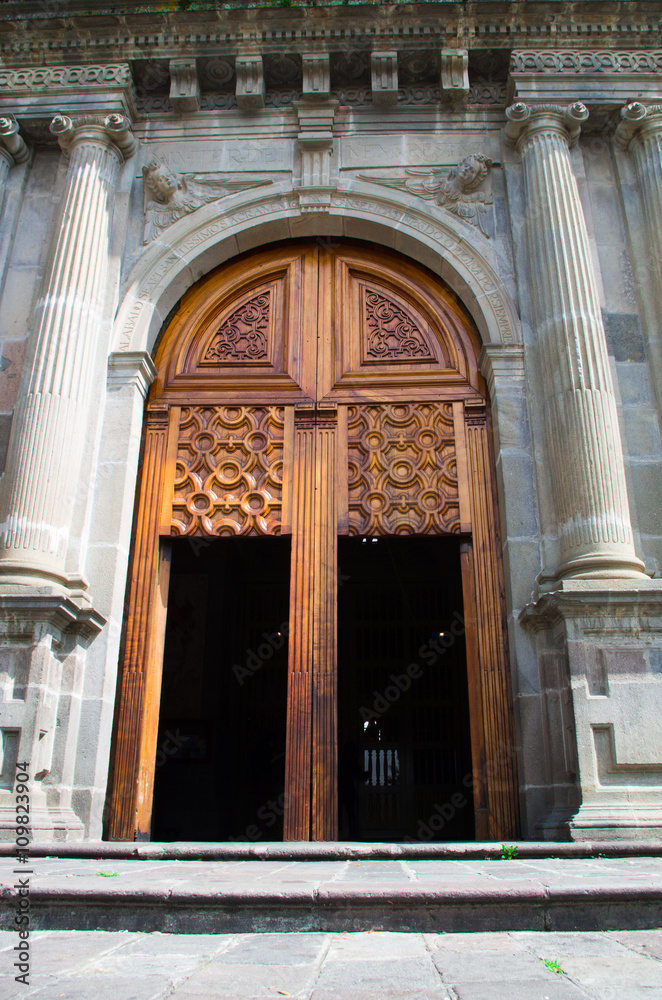 Wooden door leading into beautiful church of Guapulo located in Quito Ecuador, spanish colonial architecture and blue sky background