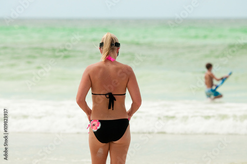 Mom in bikini swimsuit from behind at the beach.