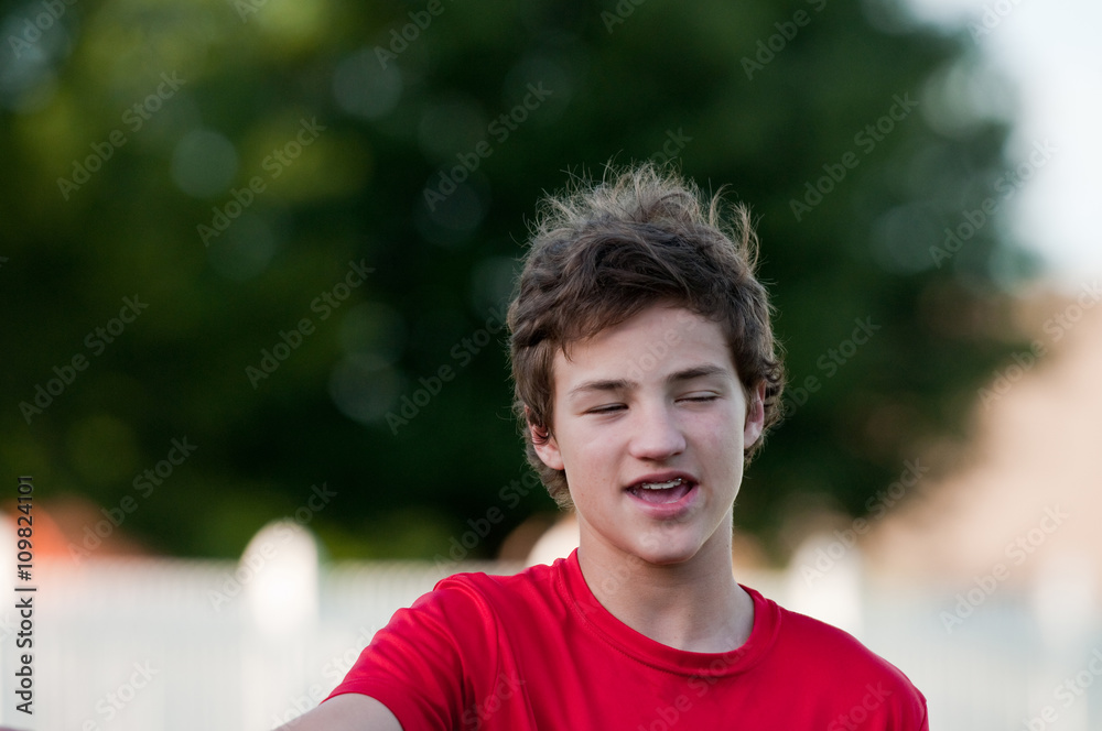 Handsome teenage boy outdoors with braces and messy hair with ey Handsome teenage boy outdoors with braces and messy hair with ey