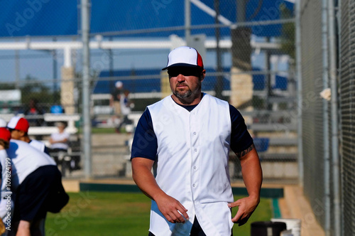 Baseball coach walking across field.