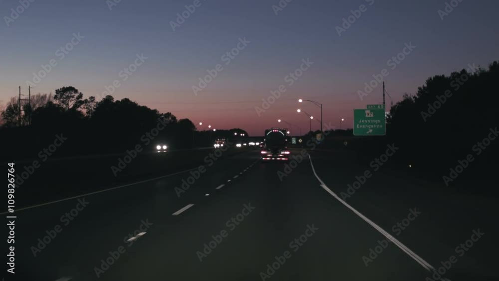 Driving along with eighteen wheeler trucks transporting freight on interstate highway at night. Driving along with eighteen wheeler trucks transporting freight on interstate highway at night.