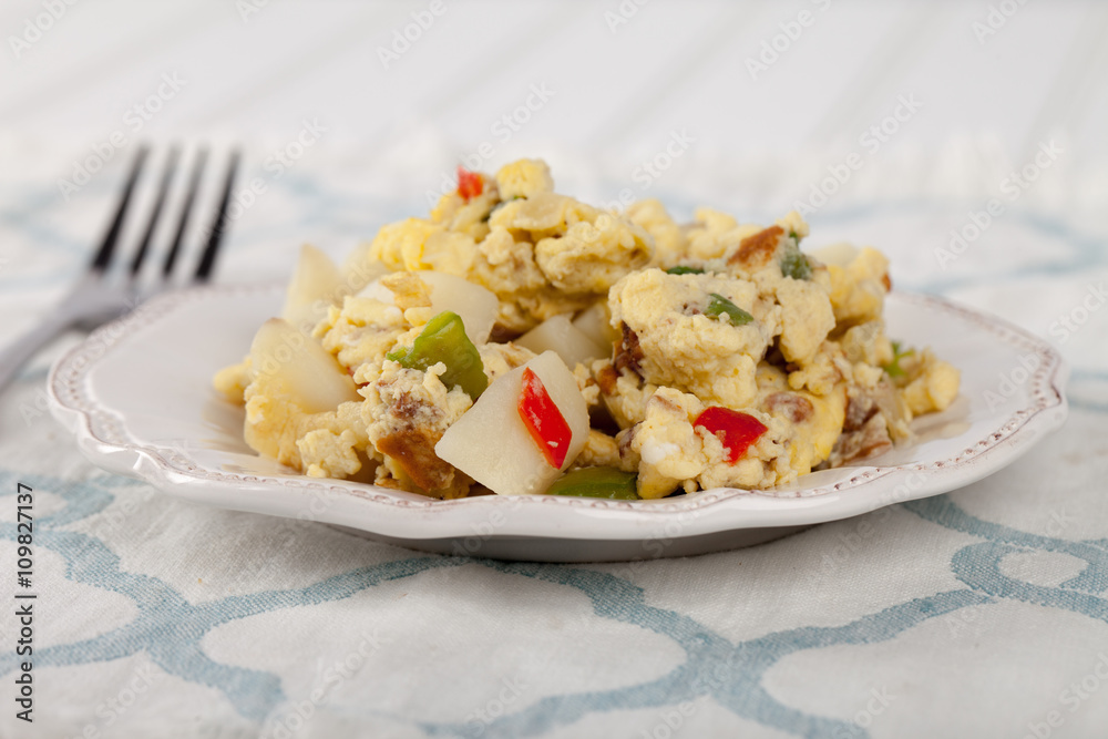 Scrambled eggs with Anaheim chilies, boiled potatoes, green peppers, and onions side view Scrambled eggs with Anaheim chilies, boiled potatoes, green peppers, and onions side view