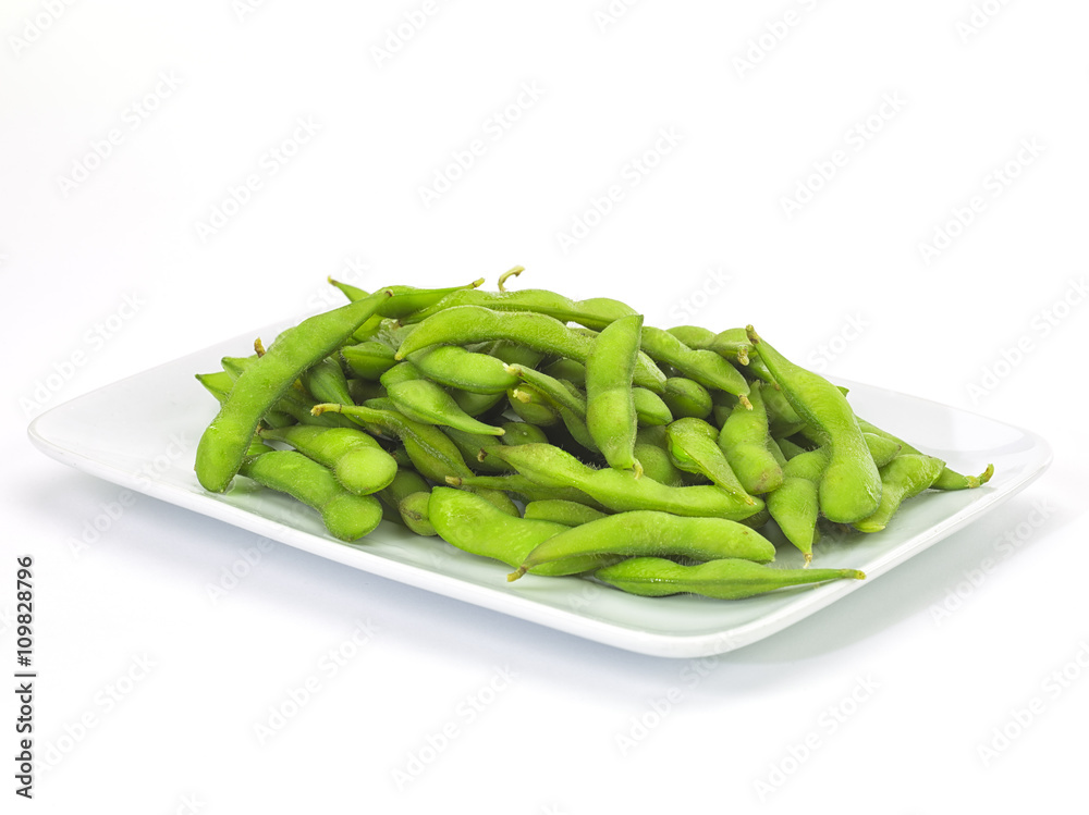 Edamame soy beans in a white ceramic dish.