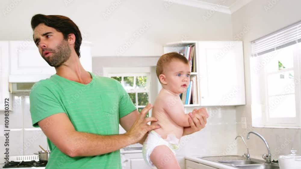 Father checking diaper of son Father checking diaper of son