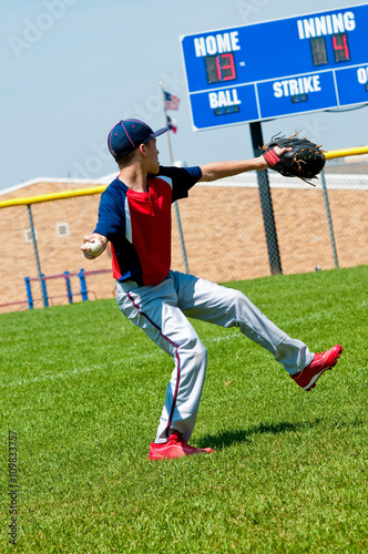 Teen baseball pitcher warming up before pitching.
