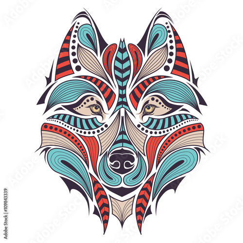 Patterned colored head of the wolf. African   indian   totem   tattoo design. It may be used for design of a t-shirt  bag  postcard and poster.