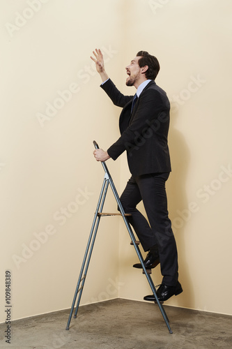 Reaching businessman on ladder, studio