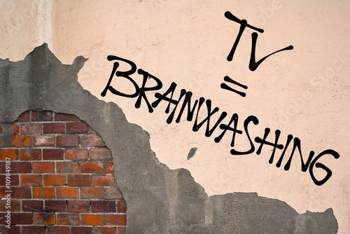 Handwritten graffiti TV = Brainwashing sprayed on the wall, anarchist aesthetics. Appeal to avoid watching and listening media of mainstream and popular mass culture photo