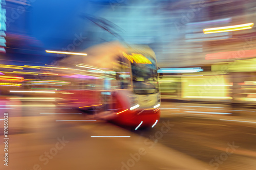 Red tram on urban city street with motion blur effect.