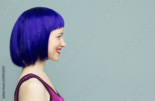 Smiling girl in a blue wig with red lips