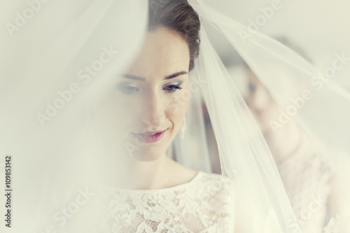 Uśmiechnięta panna młoda na tle swojego welonu w dniu ślubu - przygotowania