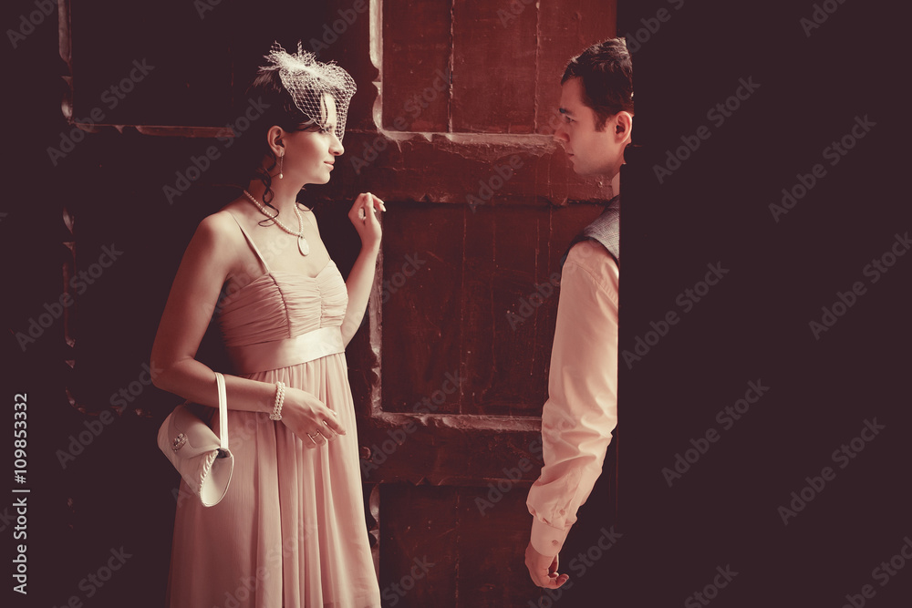 Pretty couple on the vintage doorway background. Retro styled to