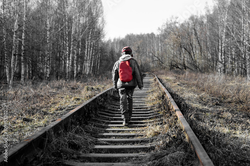 little boy goes deep into the forest along the rails, black and white, left several colors