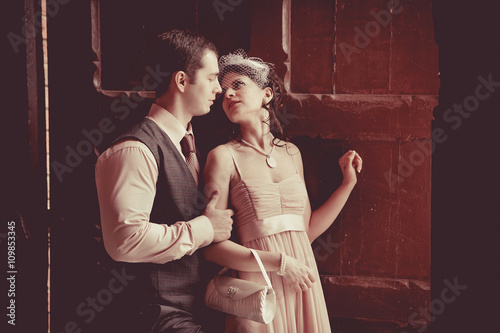 Pretty embracing couple on the vintage doorway background.
