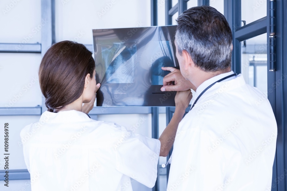Doctors examining a x report Doctors examining a x report