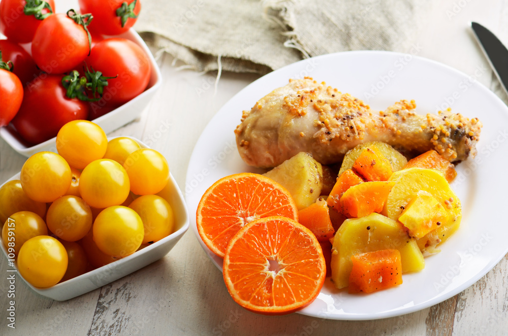 chicken drumstick cooked in spices with vegetables in the plate