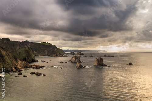 Cliffs and ocean at sunset. Cloudy sky, Cantabria, Spain