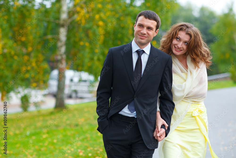 Woman grimaces holding man's hand and walking around a park Woman grimaces holding man's hand and walking around a park