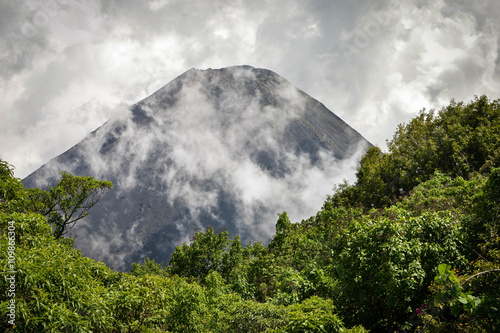 The perfect peak of the active and young Izalco volcano in El Salvador, covered in clouds. Cerro Verde National Park.