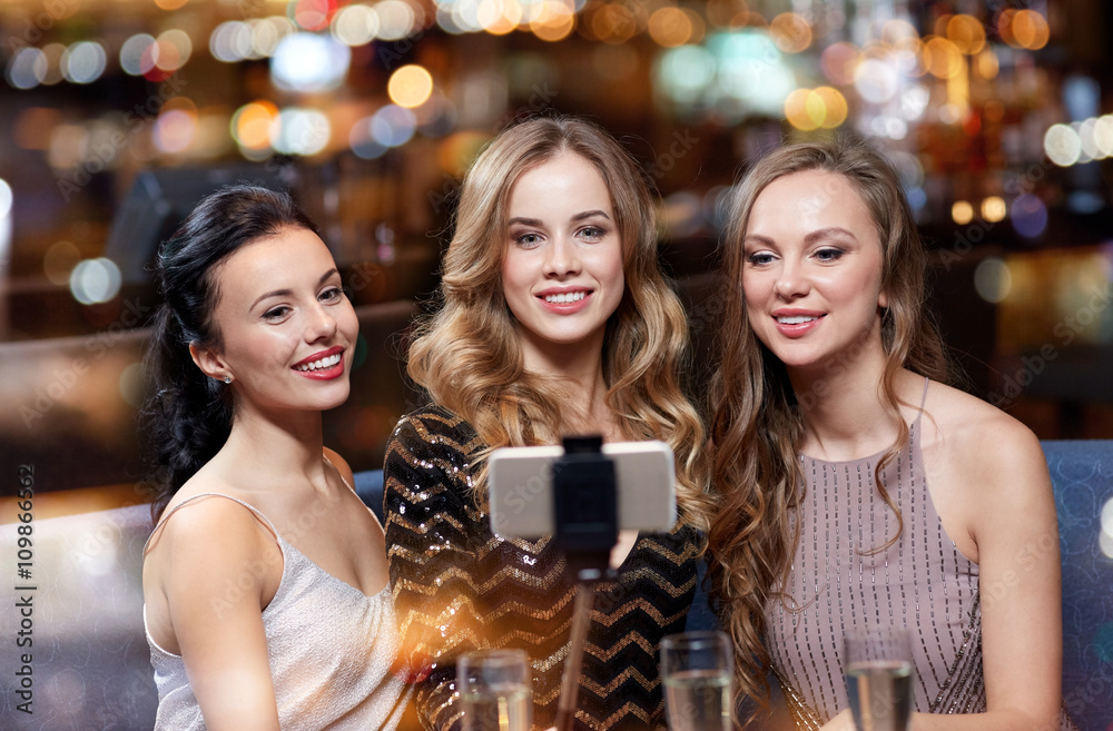 women with smartphone taking selfie at night club women with smartphone taking selfie at night club