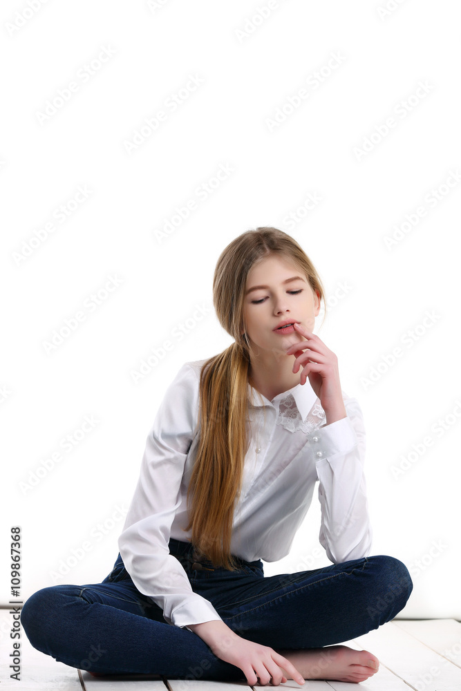 schoolgirl sitting on a mat with downcast eyes in studio schoolgirl sitting on a mat with downcast eyes in studio