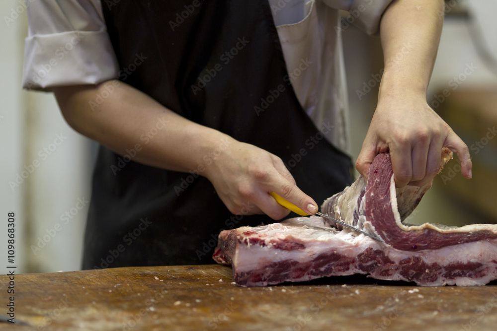 mid section of a man cutting meat with knife.