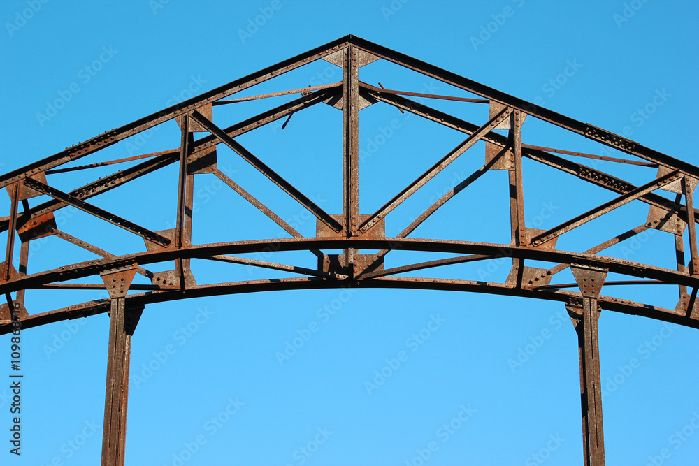 Detail of old rusty metal bridge on blue sky background