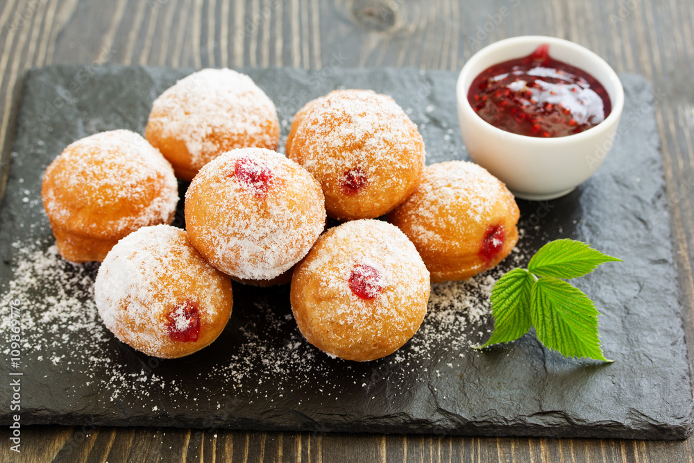 Donuts filled with raspberry jam and powdered sugar in. Donuts filled with raspberry jam and powdered sugar in.
