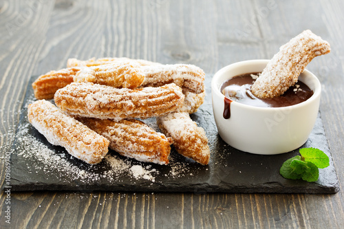 Churros with hot chocolate and powdered sugar.